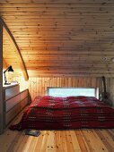 Continuous wood panelling in bedroom gallery with horizontal strip window and arched ceiling