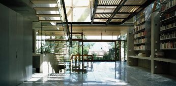 Contemporary solar house building - airy staircase to gallery with sun from above and dining area in front of wide glass wall