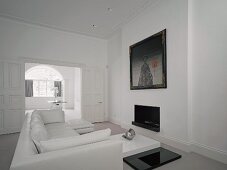 White living room with sofa, coffee table & fireplace