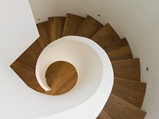 Blick von Oben auf Wendeltreppe aus Holz mit weißem Geländer