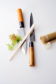 Japanische Messer, Essstäbchen und Bambusmatte für Sushi