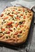 Focaccia topped with tomatoes, olive, capers