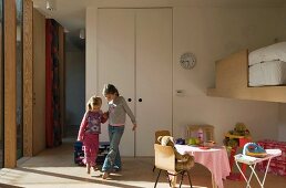 Two children playing in children's bedroom with play area & loft bed