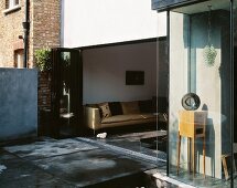 Terrace in front of living room with open folding door and view of sofa