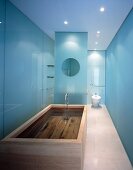 Designer bathroom with filled wooden bathtub