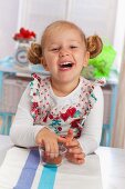 Little girl with a glass filled with cress seeds