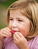 A girl eating a radish