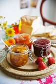 Three types of jam on a wooden board