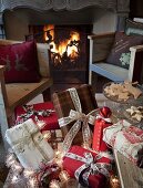 Presents tied with ribbons on bench in front of rustic armchairs and open fire