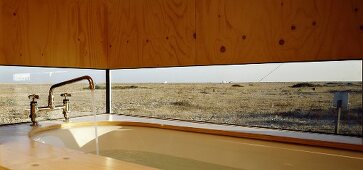 Bathtub next to panoramic window