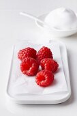 Fresh raspberries on a serving platter with cream