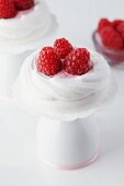Meringue nests filled with raspberry cream and raspberries