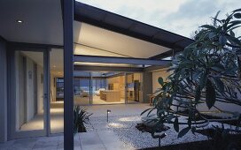 Terrace in front of contemporary house with view of illuminated interior