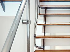 Detail of staircase with wooden treads and stainless steel balustrade