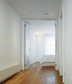 White-painted hallway with open double doors and view of bedroom