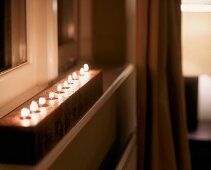 Unfocused atmospheric picture - wooden block with burning tea lights inserted