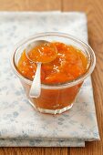 A jar of apricot jam with a spoon