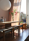 Table with designer-style, upholstered stools in front of open balcony door