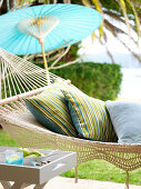 Cushions in hammock and Chinese paper parasol on terrace