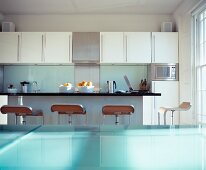 Designer bar stools in front of kitchen counter with view of wall cabinets