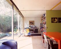 Red table in front of open, green-painted sliding wall with view of office