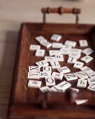 Game tiles with letters on wooden tray