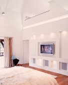 White, designer bedroom with indirect lighting in wall