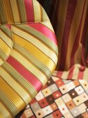 Colourful mix of patterns on chair upholstery, carpet and curtain