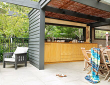 Kitchen counter and dining area on open-plan veranda of contemporary house