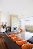 Elegant living room with corner sofa, fireplace and panoramic view of landscape