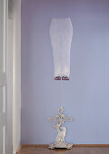 Floating artwork and cast iron umbrella stand against lilac-coloured wall in period hallway