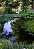 Chair with view of pond in summer garden