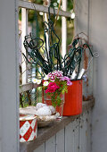 Trellis, flowers and ornaments on windowsill of garden shed