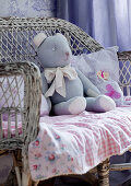 Teddy bear on gingham blanket on old wicker chair