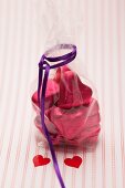 Heart-shaped chocolates wrapped in red foil in a cellophane bag