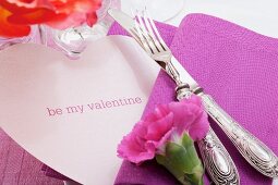 Festliches Gedeck mit Nelke und herzförmiger Tischkarte zum Valentinstag