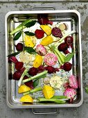 Various types of beetroot and spring onions in a roasting tin