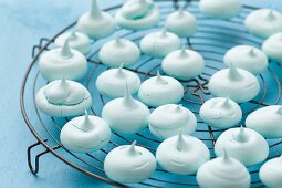 Turquoise meringues on a kitchen rack