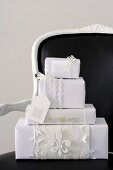 Presents wrapped in white paper on a black chair