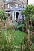 View through grasses of dining area on terrace of country house