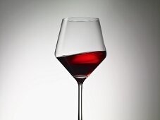 Rotwein schwappt im Glas