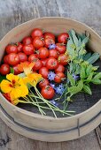 Tomaten und Gartenkräuter in einem Sieb