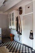 A country house bathroom with black and white floor tiles and old Delft wall tiles
