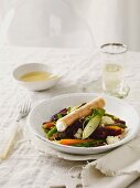 Frühlingsrollennteig mit Ziegenfrischkäse-Füllung auf Salat aus Minigemüse