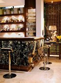 Illuminated bar clad with animal skin print and chrome bar stools
