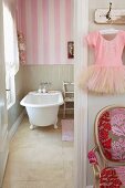 Bathroom with freestanding bath tub and pink and white striped wallpaper