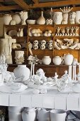 Collection of porcelain on a rustic wall shelf unit a white tile table