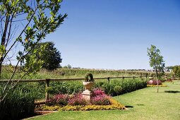 Flower bed with antique-style planter in extensive garden