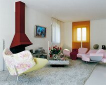 Accents of red in modern interior - floral designer armchair in front of red chimney breast and pink sofa combination on pale flokati rug