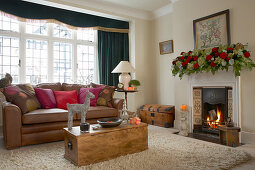 Classic, festively decorated living room; stylised stag on trunk-style coffee table and garland of roses on mantelpiece
